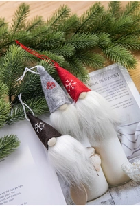 Detailed view of three wool felt Christmas gnomes with snowflake embroidery and plush textures