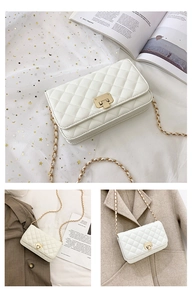 Macro shot of white quilted chain bag with metal lock and woven leather strap