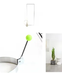 Detailed view of stainless steel fried egg mold with green handle and rivet connector