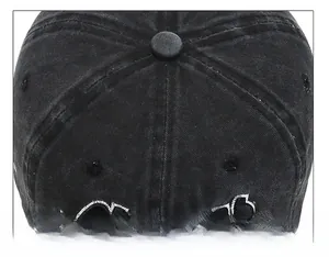 Detail of six-panel stitched crown and fabric texture on a washed black denim baseball cap
