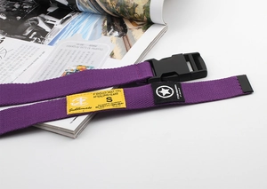 Detail view of purple canvas belt with black plastic buckle and yellow textile labels
