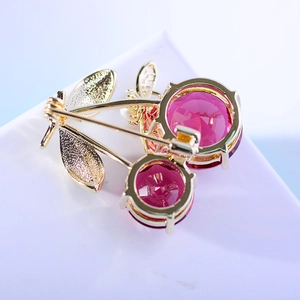 Fashionable golden cherry brooch with pink faceted gemstones shown from the back view