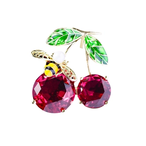 Enamel cherry and bee brooch with red crystals and green leaves on white background