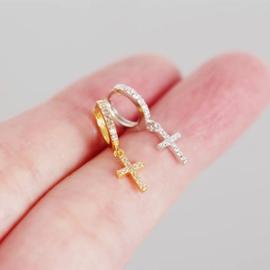Detailed macro view of S925 sterling silver cross hoop earrings with cubic zirconia stones