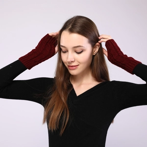 Detail of dark red cable knit fingerless gloves showing warmth and ribbed texture