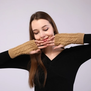 Macro shot of camel knit cable pattern texture on warm fingerless arm sleeves