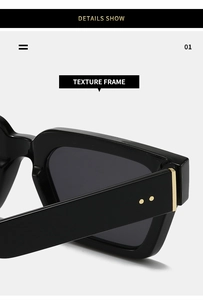 Close-up of black thick-frame sunglasses showing gold hinge details and premium texture