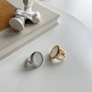 Detailed view of vintage oval shell inlay rings in gold and silver metal finishes