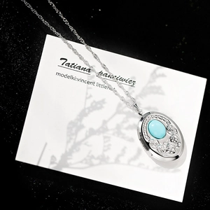 Dettaglio della collana vintage con rilievo di rosa e ciondolo in turchese blu