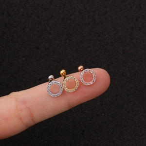 Macro shot of silver, gold, and rose gold zircon ear studs held on fingertips