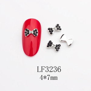 Détail de bijoux d'ongles nœuds avec strass noirs et blancs, taille 4x7mm