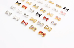 Vue macro de bijoux d'ongles en forme de nœuds avec perles et strass colorés en alliage