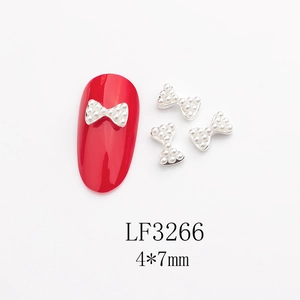 Vue macro de breloques nœud perle 4x7mm sur base argentée pour nail art DIY