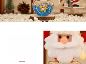 Detail view of heart-shaped Christmas candy jar with mini Santa doll and glass bottle