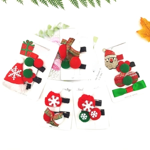 Close-up of festive Christmas hair clips featuring Santa, bows, and plush holiday elements