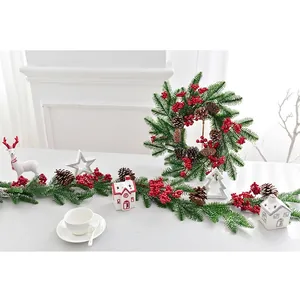 Weihnachtskranz und Girlande mit roten Beeren und Zapfen für festliche Hausdekoration