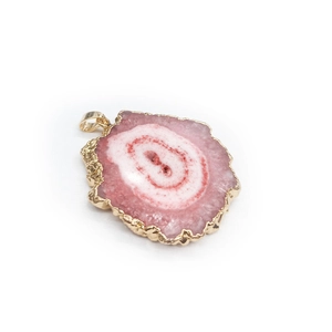 Detailed view of pink natural agate slice pendant with gold plated edges and concentric texture