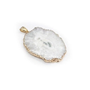 Detail of white agate slice pendant with gold plated irregular edges on white background