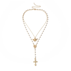 Detailed view of vintage angel medal and pearl cross drop on multi-layer gold necklace