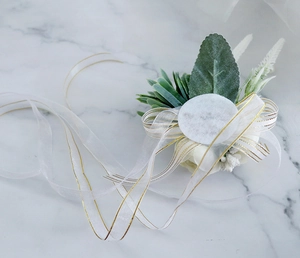 Dettaglio del corsage da matrimonio stile foresta con rosa bianca, succulente e nastro