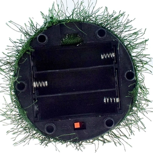 Detail view of the black plastic base with a red switch and 3-battery compartment for a toy