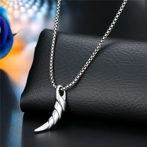 Close-up of antique silver horn pendant on a punk style stainless steel chain