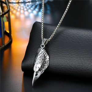 Detailed close-up of a carved silver eagle head pendant on a square box chain necklace