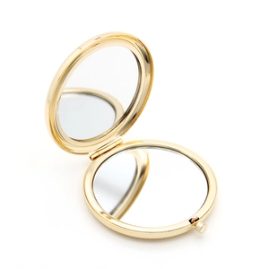 Portable golden round metal makeup mirror with foldable double-sided design and shiny finish