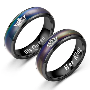 Primer plano de anillos de pareja de acero negro con grabados His Queen y Her King