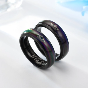 Vista detallada de los anillos de pareja con corona grabada, incrustación irisada y Her King