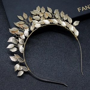 Close-up of golden alloy leaf headband with detailed veins on black background
