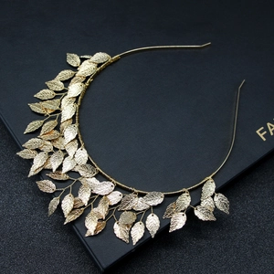 Detail view of a golden leaf headband with clear metal textures on a black gift box