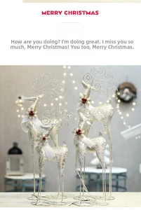 Detail of glittered reindeer statues with white fur scarves and berries for Christmas decor