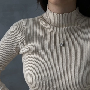 Square clear crystal pendant necklace with silver chain shown on a knit sweater