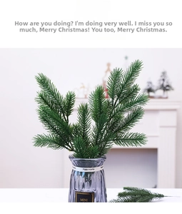 Artificial pine branch needles in a glass vase for festive indoor Christmas decoration