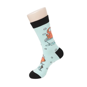 Close-up of mint green mid-calf sock featuring an orange monster cartoon design