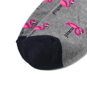 Détail de chaussettes tricotées grises à motifs flamants roses et orteils contrastés