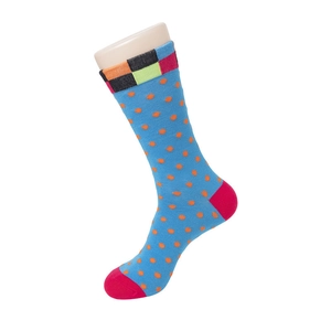 Détail de chaussettes bleues à pois orange avec revers à carreaux colorés et texture