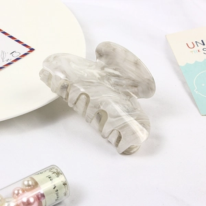 Macro shot of large marble pattern hair claw clip in white and grey acetate material