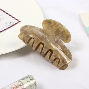Close-up of marble pattern acetate hair claw clip with beige and brown textures