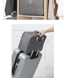 Sac de voyage gris avec sangle de bagage fixé sur la poignée d'une valise argentée