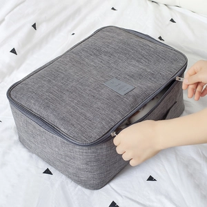 Grand sac de voyage gris avec large ouverture zippée montrant une grande capacité interne