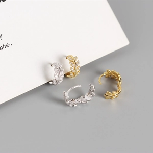 Detailed view of silver and gold olive leaf earrings featuring sparkling zircon inlay