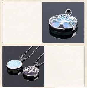 Detail showing intricate Tree of Life engraving on round opal stone pendant with silver frame