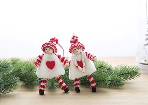 Detail of handmade Christmas felt dolls with wooden heads and knitted hats on a festive branch