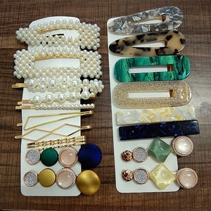 Detail of assorted handmade pearl bows and resin marble hair clips on wooden background