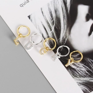 Detail of S925 silver letter earrings with white zircon inlays in gold and silver