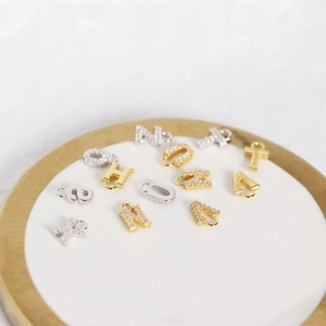 Close-up of S925 sterling silver alphabet pendants with white zircon in gold and silver