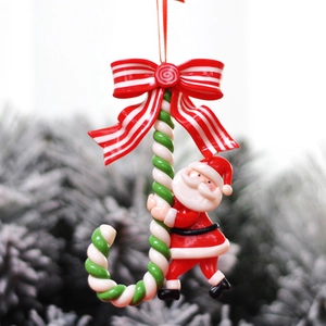 Christmas tree hanging ornament featuring Santa Claus climbing a red candy cane with bow