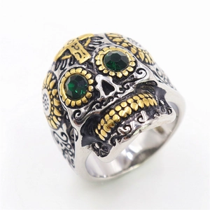 Mens stainless steel sugar skull ring with gold accents and green gemstone eyes